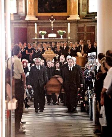 The coffin is carried out of the church