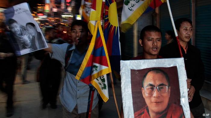 Exile Tibetans hold portraits of spiritual leader the Dalai Lama, right, and 21-year-old monk Phuntsog and participate in a candlelit vigil to honor the monk who set himself on fire in an anti-government protest, in Dharmsala, India, Thursday, March 17, 2011. Phuntsog, who like many Tibetans goes by only one name, set himself on fire Wednesday afternoon on a main street near the Kirti monastery in Aba town, in Sichuan province, said Kusho Tsering, a monk now living in Dharmsala, India. A state news agency said the monk died Thursday. (AP Photo/Ashwini Bhatia) 