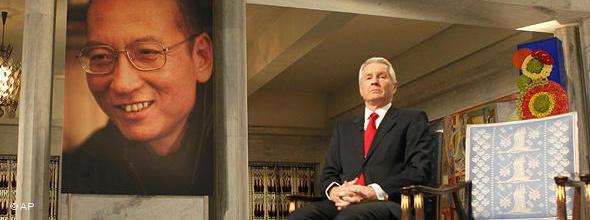 The chairman of the Norwegian Nobel Committee, Thorbjoern Jagland, sits next to an empty chair during the ceremony in Oslo City Hall to honour this years Nobel Peace Prize winner, jailed Chinese dissident Liu Xiaobo whose picture hangs at left and is represented by the empty chair. (AP Photo Heiko Junge, pool)